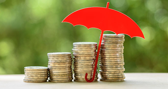 A red umbrella sheltering rising stacks of coins, symbolising income protection